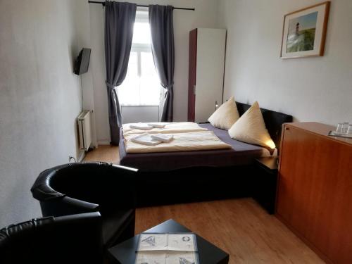 a small room with a bed and a window at Hotel Hohenzollernhof in Cuxhaven