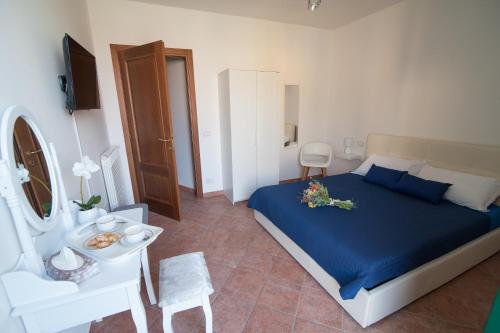 een slaapkamer met een blauw bed en een witte stoel bij B&B CA DEL SOLE in Serravalle Scrivia