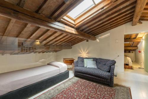 a bedroom with a bed and a couch and a window at Like Home in Verona