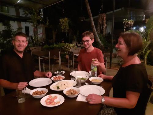 a group of people sitting around a table with food at Kutumbaya in Anuradhapura