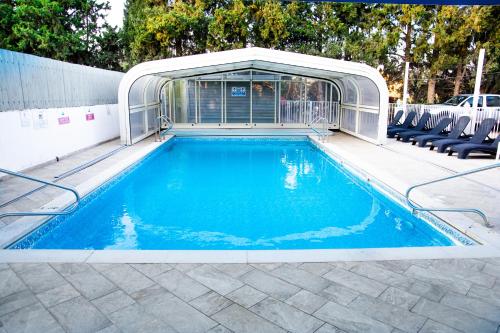 a swimming pool with a pavilion and a swimming poolvisor at Etzel Tami Hospitality in Neot Golan