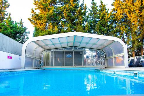 a large swimming pool with a building next to it at Etzel Tami Hospitality in Neot Golan