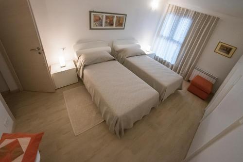 - une chambre avec un lit doté de draps blancs et une fenêtre dans l'établissement ALL'ANTICO CAMPANILE, à Rovigo