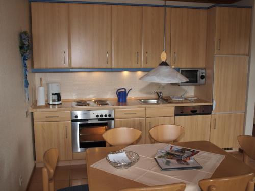 a kitchen with wooden cabinets and a table with chairs at Haus Reimann in Altenau