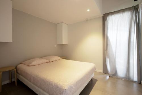 une chambre avec un lit blanc et une fenêtre dans l'établissement PURA VIDA # meublé plein de charme océan montagne, à Villefranque