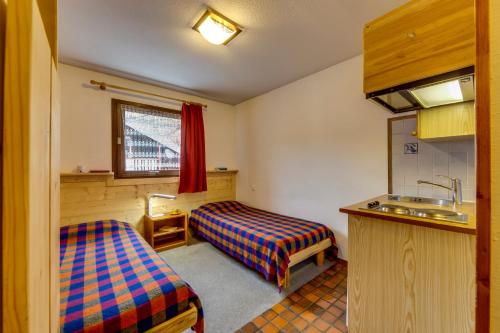 a small room with two beds and a sink at R&eacute;sidence Studio Sakura in Val dʼIs&egrave;re