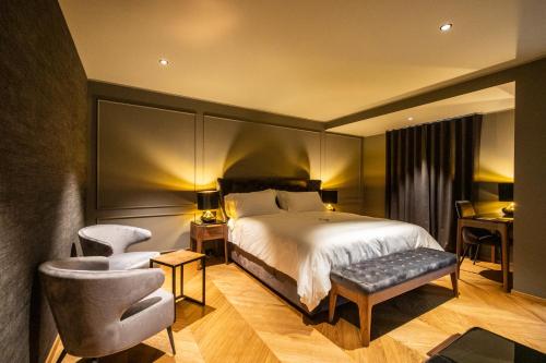 a bedroom with a bed and a chair and a desk at DAM boutique hotel & restaurant in Nova Gorica
