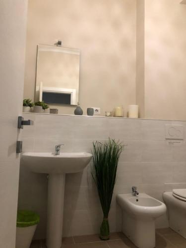 a bathroom with a sink and a mirror and a toilet at River View in Fiumicino