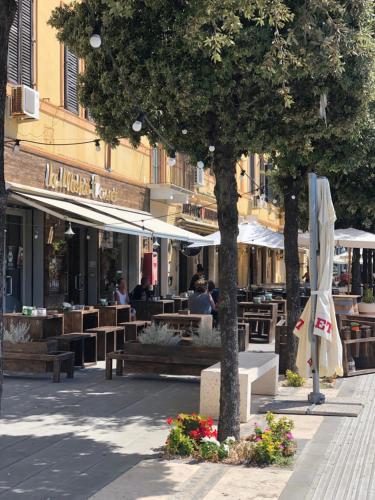 a cafe with tables and umbrellas on a city street at River View in Fiumicino