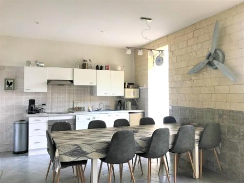 eine Küche mit einem Tisch und Stühlen im Zimmer in der Unterkunft LE COEUR MEDOCAIN in Saint-Vivien-de-Médoc