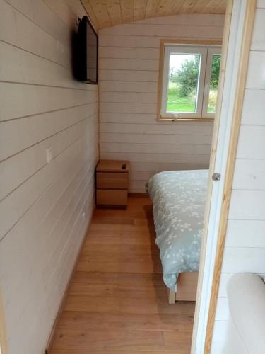 a small room with a bed and a window at La Roulotte Julyana in Vielsalm