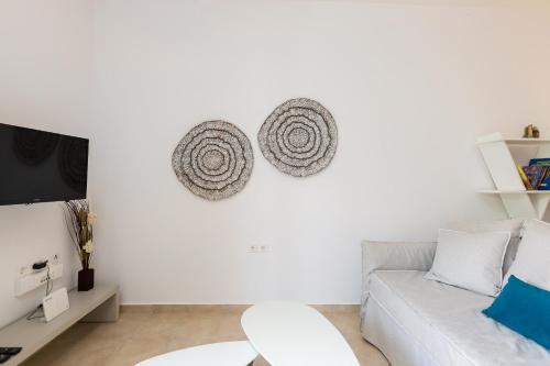 a white living room with a couch and a tv at Chris House in Loutra