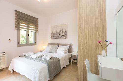 a white bedroom with a bed and a sink at Chris House in Loutra