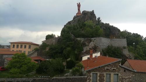 a mountain with a statue on top of it at Chambres d'hôtes La Prévôté - Ancien couvent contre la Cathédrale in Le Puy en Velay