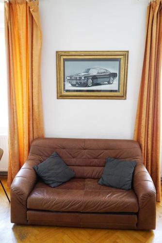 a brown couch in a living room with a picture of a car at Sixties Appartement in Graz