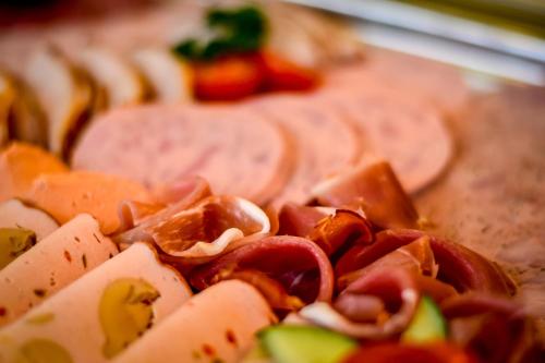 a close up of a pizza with bacon and tomatoes at Hotel & Restaurant Alter Speicher in Greifswald