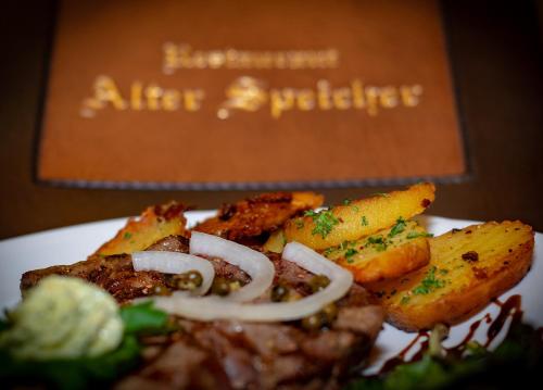 a plate of food with fries and onions on it at Hotel & Restaurant Alter Speicher in Greifswald