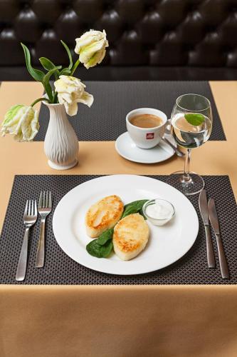 a table with a plate of food and a cup of coffee at Conviva in Panevėžys