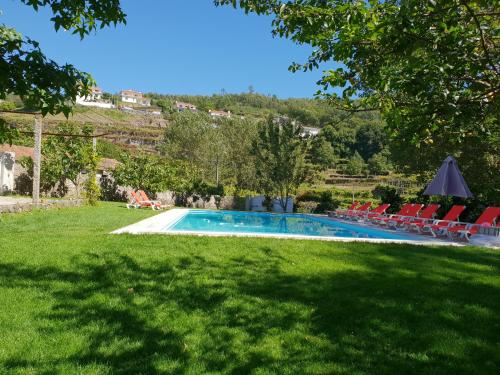 - une piscine dans une cour gazonnée avec des chaises dans l'établissement Casa dos Namorados, à Vale de Cambra