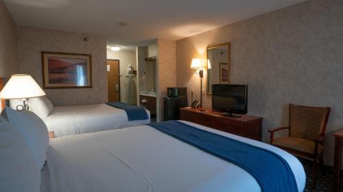 um quarto de hotel com duas camas e uma televisão em Miles City Hotel & Suites em Miles City