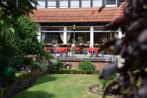 a garden with tables and chairs on a patio at Gasthof Waldesruh in Saerbeck