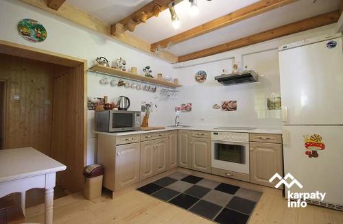 a kitchen with a refrigerator and a stove top oven at Садиба У Гайдука in Vizhenka