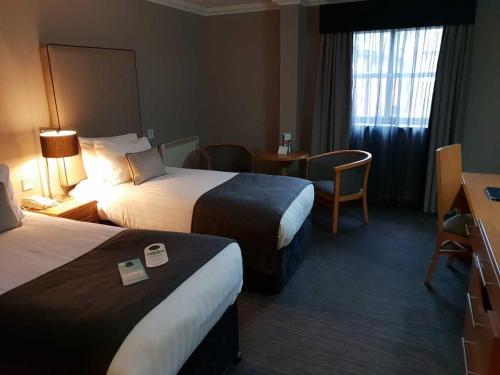 a hotel room with two beds and a table at The Worcester Whitehouse Hotel in Worcester
