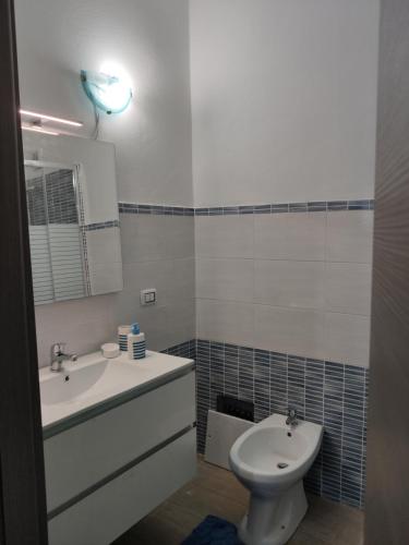 a bathroom with a sink and a toilet and a mirror at Sa Dommu 'e su coro in Triei