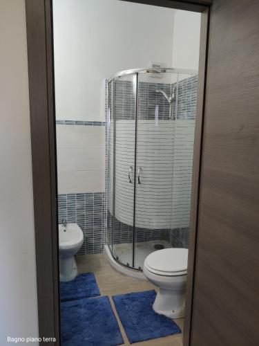 a bathroom with a toilet and a shower and a sink at Sa Dommu 'e su coro in Triei
