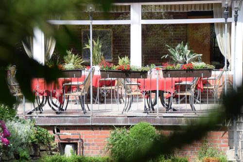 a table and chairs on a porch with plants at Gasthof Waldesruh in Saerbeck