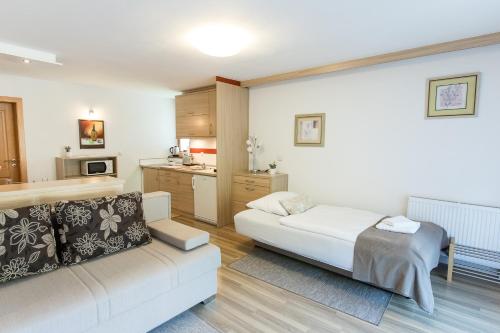 a living room with a couch and a kitchen at Apartment Natur in Bled