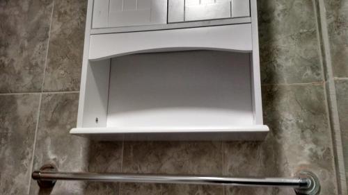 a white cabinet above a toilet in a bathroom at casa completa Balmaceda 77 in Concepción