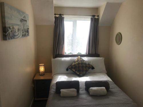 ein Schlafzimmer mit einem Bett mit zwei Kissen und einem Fenster in der Unterkunft Weston Shore in Southampton