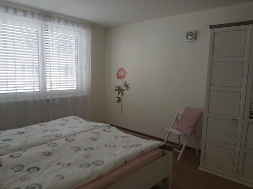 ein Schlafzimmer mit einem Bett, einem Stuhl und einem Fenster in der Unterkunft Vienna Home48 in Wien
