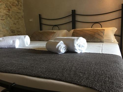 ein Bett mit weißer Bettwäsche und Kissen darauf in der Unterkunft BB Masotte in Sommacampagna