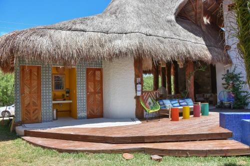 a small house with a thatched roof and a deck at Soho Boutique Holbox - Adults Only in Holbox Island