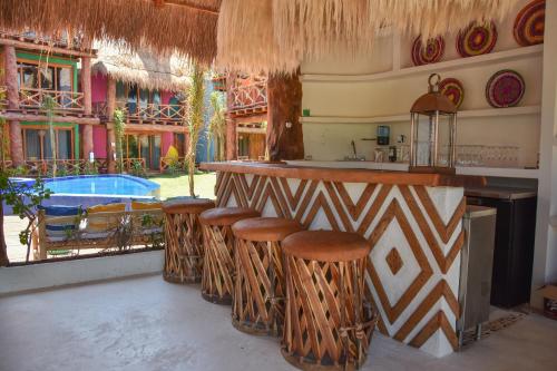 a bar with stools in a room with a pool at Soho Boutique Holbox - Adults Only in Holbox Island