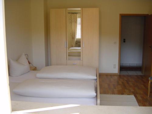 two beds in a room with a mirror at Landgasthof Schuck in Idar-Oberstein