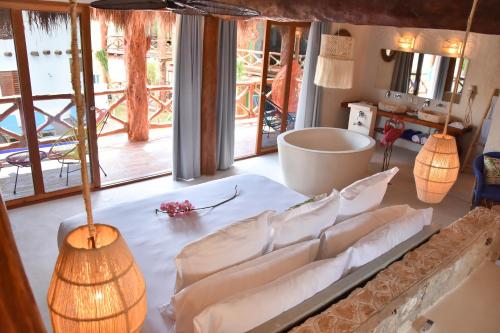 a living room with white furniture and large windows at Soho Boutique Holbox - Adults Only in Holbox Island