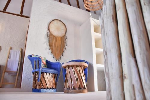two blue chairs and a mirror on a wall at Soho Boutique Holbox - Adults Only in Holbox Island