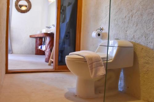 a bathroom with a toilet and a mirror at Soho Boutique Holbox - Adults Only in Holbox Island
