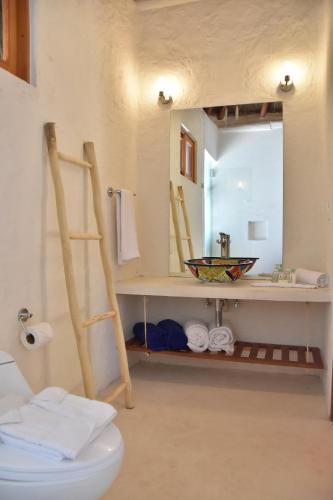 a bathroom with a sink and a toilet and a mirror at Soho Boutique Holbox - Adults Only in Holbox Island