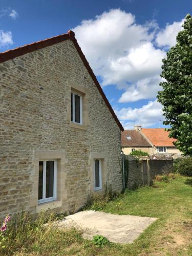 ein altes Steinhaus mit zwei Fenstern in der Unterkunft Gite Bord de Mer 80 m2 in Bernières-sur-Mer