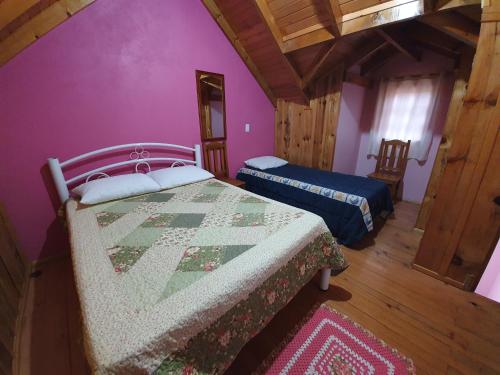 1 dormitorio con 2 camas y paredes moradas en Pousada Canto de Pássaros, en Painel