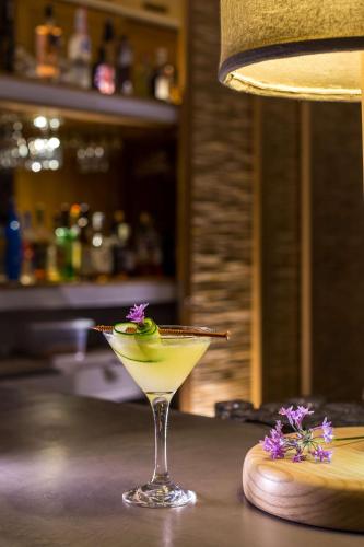 a drink in a martini glass sitting on a table at Kouros Exclusive Hotel & Suites - Adults Only in Faliraki
