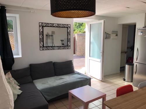 a living room with a couch and a table at GITE BORD DE MER in Bernières-sur-Mer