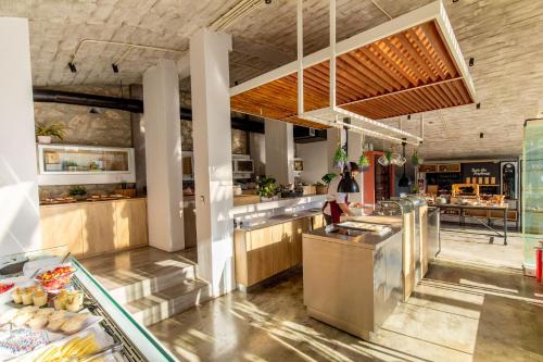 a restaurant kitchen with a counter with food at Kouros Exclusive Hotel & Suites - Adults Only in Faliraki
