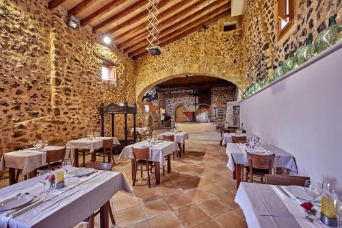 a restaurant with tables and chairs in a room at Agroturismo Alquería Blanca in Bunyola