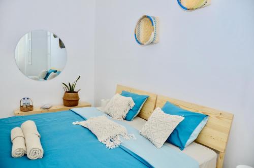 a bed with blue and white pillows and a mirror at Casa Sodadi in Praia