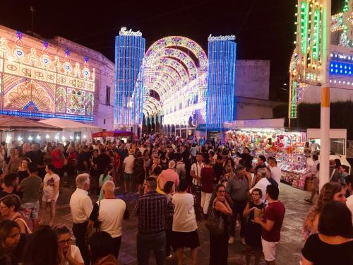 uma multidão de pessoas em frente a um mercado à noite em B&B Santa Lucia em Sogliano Cavour